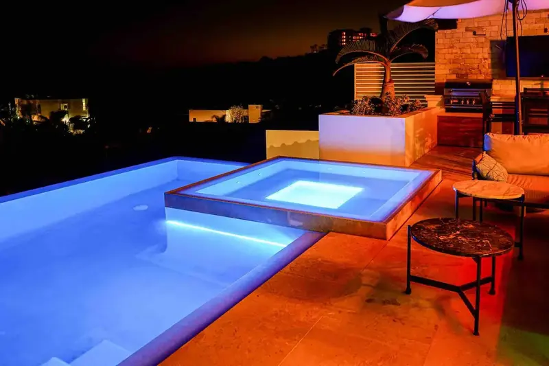 Casa Texas pool and hot tub lit blue at night